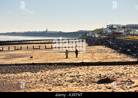 Paare, die einen Hund am Strand von Hornsea East Yorkshire UK Stockfoto