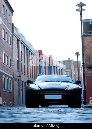 Grand Tourer schwarz Aston Martin DB9 in städtische Straße mit roten Ziegelsteinen geparkt und gepflasterten Gassen in wohlhabenden Leeds Stockfoto
