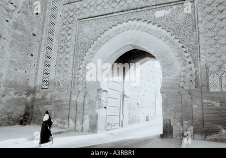 Eine Frau in yashmak Gesichtsschleier Spaziergänge durch das Tor Bab Mansour in der Medina von Meknes Kasbah in Marokko im Maghreb in Nordafrika, Sahara. Reisen Stockfoto