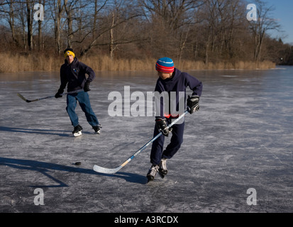 Jungs spielen Eishockey auf einem zugefrorenen Teich Stockfoto