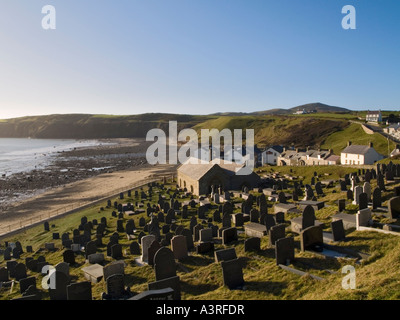 12. Jahrhundert Kirche St Hywyn s Eglwys Hywyn Sant Friedhof Dorf und leeren Strand bei Ebbe in Aberdaron Bay Lleyn Halbinsel Stockfoto