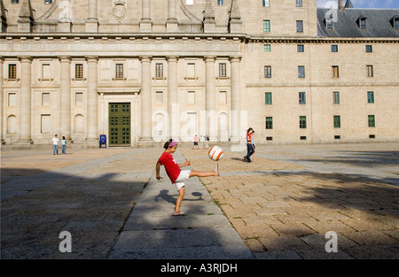 Ein Kind spielt Fußball vor El Escorial Fassade Spanien Stockfoto