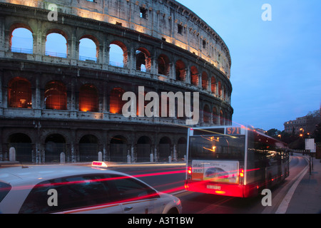 Bus und Taxi vorbei das Kolosseum auf der Via Dei Fori Imperiali im Feierabendverkehr Rom Italien Stockfoto