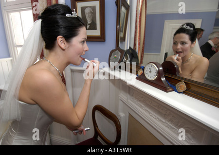 Eine hübsche Braut anziehen Lippenstift an ihrem Hochzeitstag, Wales UK Stockfoto