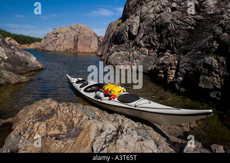 Ein weißes Meer Kajak liegt in einer geschützten Bucht mit Felswände am Lake Superior in der Nähe von Marquette, Michigan Stockfoto