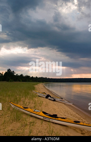 Eine Gruppe von Meer Kajaks am Forellen Bay Beach auf Grand Island National Recreation Area in Munising Michigan mit dramatischen Himmel Himmel Stockfoto