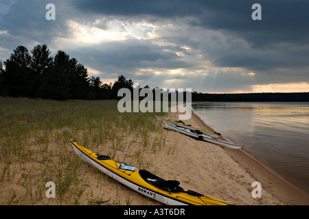 Eine Gruppe von Meer Kajaks am Forellen Bay Beach auf Grand Island National Recreation Area in Munising Michigan mit dramatischen Himmel Himmel Stockfoto