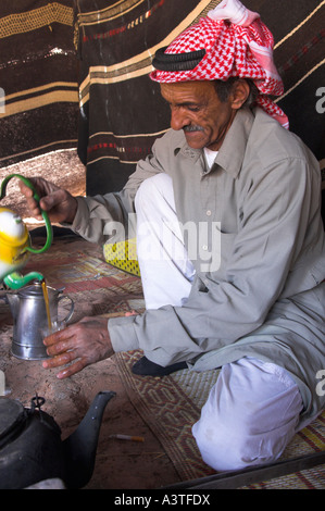 Jordanien Wadi Rum Wüste Beduinen camp Beduinen Männer tragen Keffyeh Bildniss eines strömenden Beduinentee in ein Glas Tee trinken Stockfoto