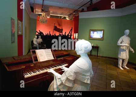 Weiblich Schaufensterpuppe im Biedermeierstil am Klavier sitzen in einem historischen Wohnzimmer gekleidet, Hintergrund, eine Revolution Stockfoto