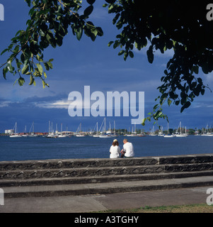 Der größte Yachthafen von Promenade paar sitzen auf Wand mit Baumblätter overhead innerorts Apia auf Upolu Insel West-Samoa Stockfoto