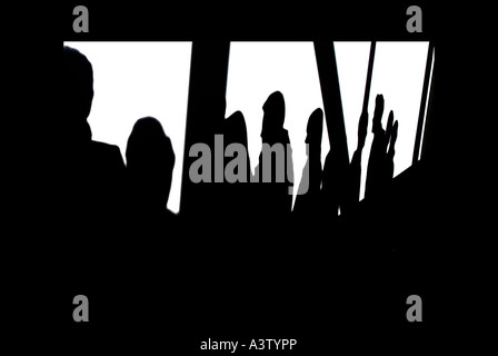 Menschen werfen lange Schatten auf Wände, wie sie in Glasgow pendeln. Bild von Jim Holden. Stockfoto