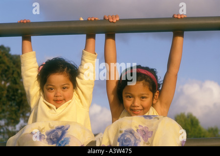 2 zwei asiatischen amerikanischen Schwestern spielen auf Zaun-Schiene Stockfoto