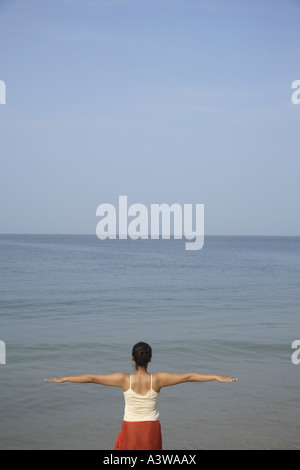 Frauen im Urlaub entspannen, trainieren, stehen Yoga Asanas genießen am Strand Sonne Sand Meer Stockfoto