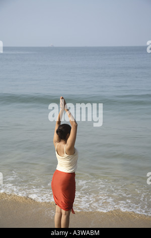 Frauen im Urlaub entspannen, trainieren, stehen Yoga Asanas genießen am Strand Sonne Sand Meer Stockfoto