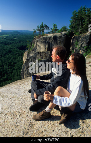 PAAR GENIEßT DIE AUSSICHT VON OBEN AUF KATHEDRALE LEDGE, ECHO LAKE STATE PARK IN DER NÄHE VON NORTH CONWAY, NEW HAMPSHIRE. SOMMER Stockfoto