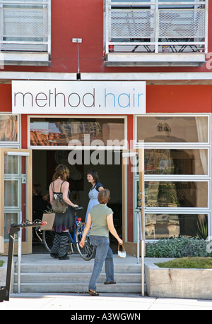 Junge Frauen reden vor einer städtischen Friseursalon Stockfoto