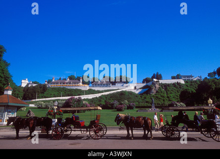 PFERDEN GEZOGENE KUTSCHE VERKEHR AUF DEN STRAßEN VON MACKINAC ISLAND MICHIGAN UNTER FORT MACKINAC IM HINTERGRUND Stockfoto