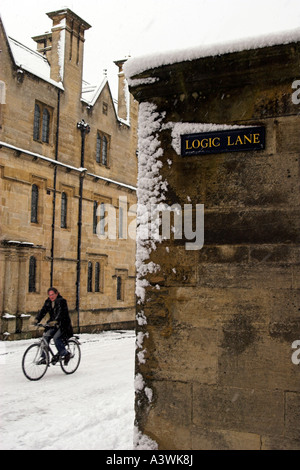 Mann mit Fahrrad unterwegs im Winterschnee, 'Logik Lane' und [Merton College], Universität Oxford, Oxfordshire, England, UK Stockfoto