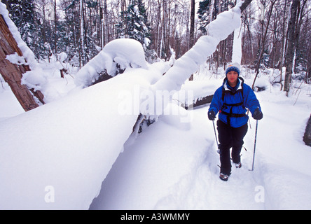 Ein Schneeschuhwanderer Wanderungen durch Neuschnee auf einem Winterwanderweg in dargestellter Felsen-Staatsangehöriger Lakeshore in der Nähe von Munising Mich Stockfoto