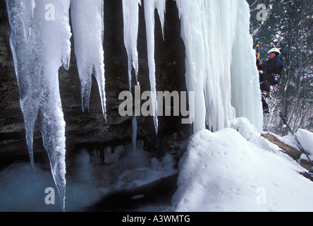 Eine weibliche Eiskletterer beginnt einen Aufstieg auf einem gefrorenen Wasserfall in dargestellter Felsen-Staatsangehöriger Lakeshore in der Nähe von Munising Mich Stockfoto