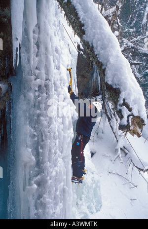 Eine weibliche Eiskletterer beginnt einen Aufstieg auf einem gefrorenen Wasserfall in dargestellter Felsen-Staatsangehöriger Lakeshore in der Nähe von Munising Mich Stockfoto