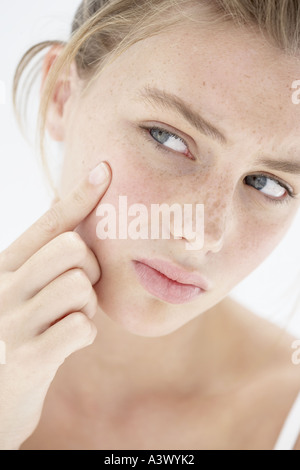 Eine junge Frau, die ihre Pickel Behandlung Stockfoto