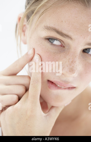 Eine junge Frau, die ihre Pickel Behandlung Stockfoto