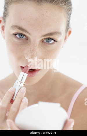 Eine junge Frau, die Anwendung von Lippenstiften Stockfoto