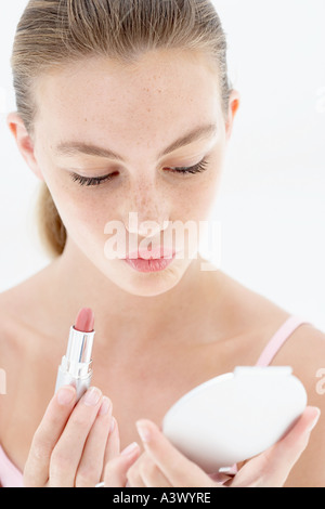 Eine junge Frau, die Anwendung von Lippenstiften Stockfoto