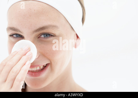 Eine junge Frau Gesicht mit Wattepad abwischen Stockfoto