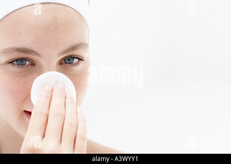 Eine junge Frau Gesicht mit Wattepad abwischen Stockfoto