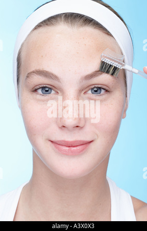 Eine junge Frau, die Augenbrauen Bürsten hautnah Stockfoto