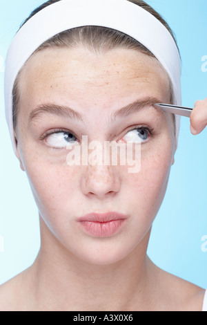 Eine junge Frau, die Augenbrauen zupfen hautnah Stockfoto