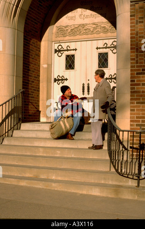 Frau Alter von 70 Jahren schütteln Obdachlose Hand des Mannes Alter 50 in der Kirche. St Paul Minnesota USA Stockfoto