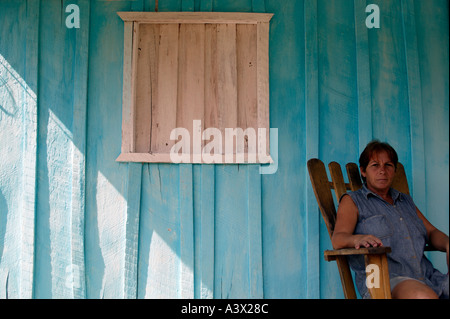 Eine kubanische Frau sitzt auf der Veranda ihres Hauses im Dorf Viñales, Pinar del Rio Province, Kuba, West Indies. Stockfoto