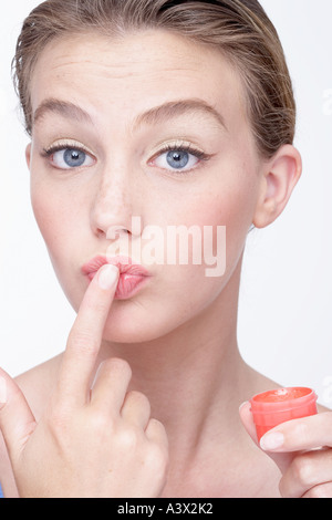 Junge Frau Anwendung Lippencreme Stockfoto