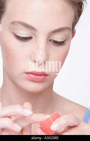 Junge Frau Anwendung Lippencreme Stockfoto