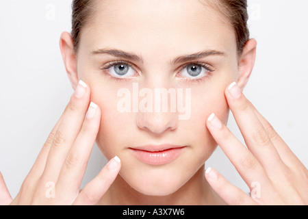 Young woman holding hands to face looking at camera Stockfoto