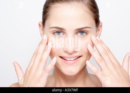 Young woman holding hands to face smiling at camera Stockfoto