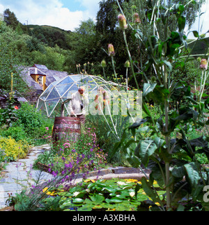 Besucher, die schnüffeln Pflanzen im Kräutergarten im Zentrum für Alternative Technologie Machynlleth Powys Wales UK KATHY DEWITT Stockfoto