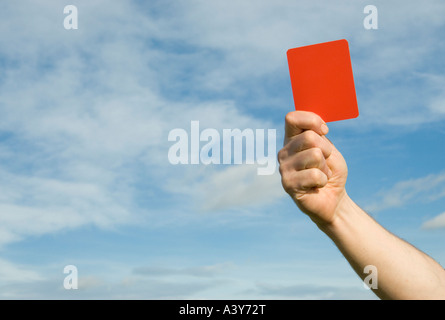 Nahaufnahme des Schiedsrichters, der eine rote Karte vor einem blauen Himmel zeigt Stockfoto