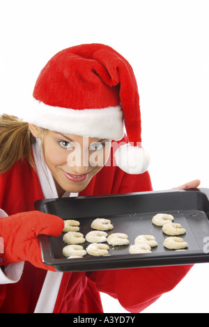 Junge Frau im Weihnachtsmann-Kostüm bietet Cookies auf Tablett Stockfoto