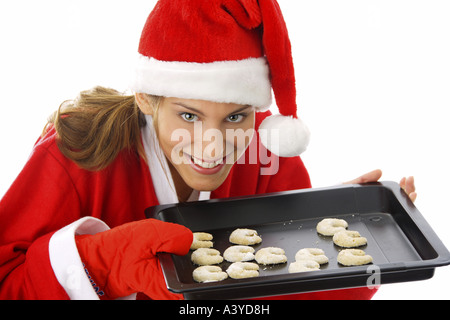 Junge Frau im Weihnachtsmann-Kostüm bietet Cookies auf einem Tablett Stockfoto