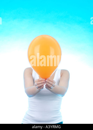 Junge Frau mit farbigen aufgeblasene Luftballons vor einem blauen Hintergrund alleine fertig werden, für eine Party oder Feier Veranstaltung Stockfoto