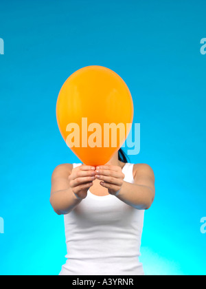 Junge Frau mit farbigen aufgeblasene Luftballons vor einem blauen Hintergrund alleine fertig werden, für eine Party oder Feier Veranstaltung Stockfoto