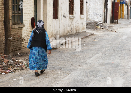 Alte Frau Walking Down Old Town Street Stockfoto