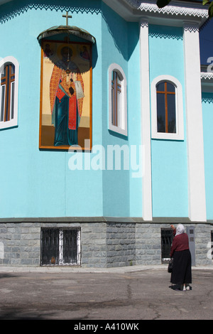 Alte Frau vor St. Nicholas Kathedrale beten Stockfoto