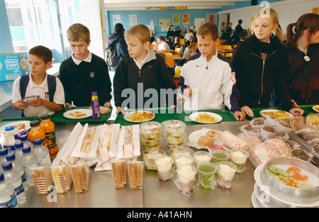 Schüler-Warteschlange für Schule Abendessen vor Dessert Theke in Schule Mensa UK bezahlen Stockfoto