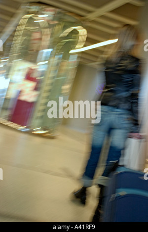 Frau, die ihr Gepäck und telefonieren mit Handy im Flughafen Nantes Frankreich Stockfoto