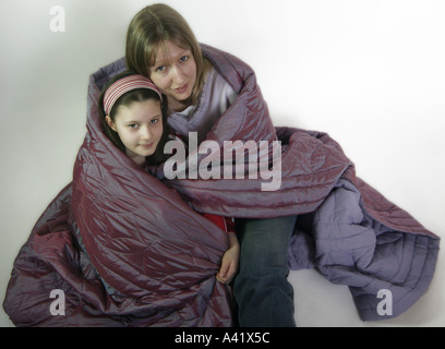 Jungen heranwachsenden Mädchen und Reife Frau zusammen eingewickelt in eine Decke in besinnliche Stimmung Stockfoto
